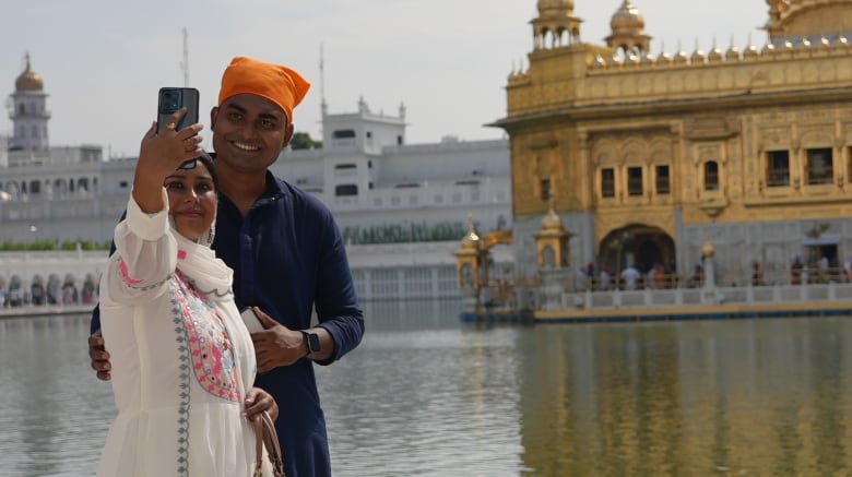 A couple snaps a selfie in front of the Golden Temple in Amritsar, India.